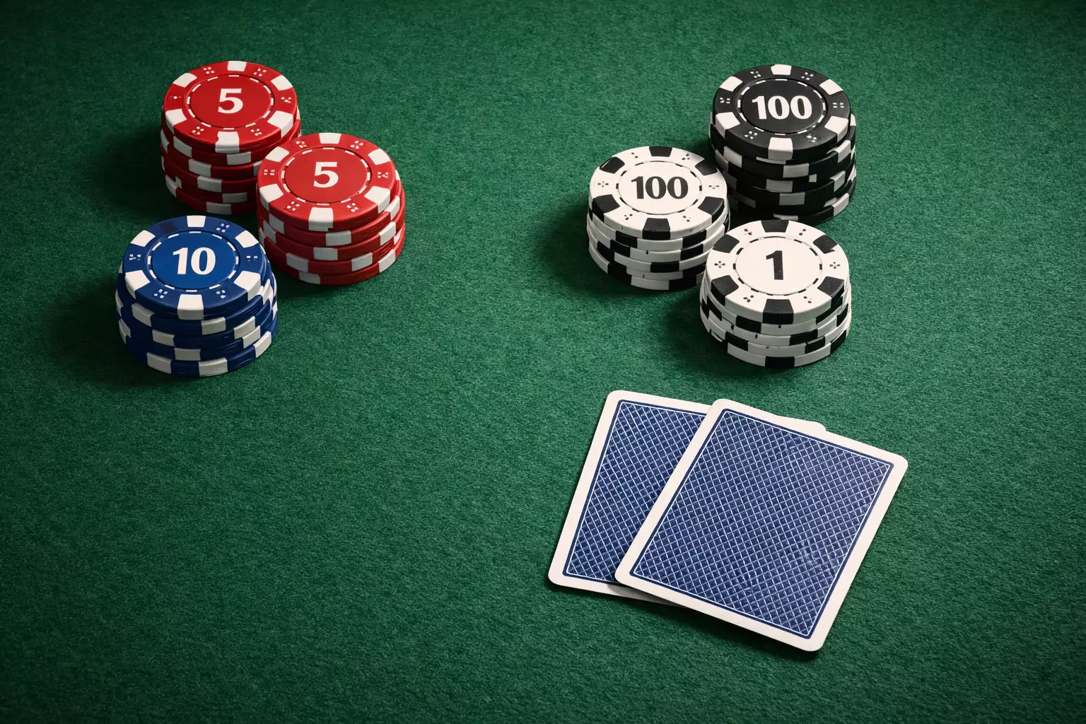Table de poker avec des jetons colorés et des cartes posées sur le tapis vert